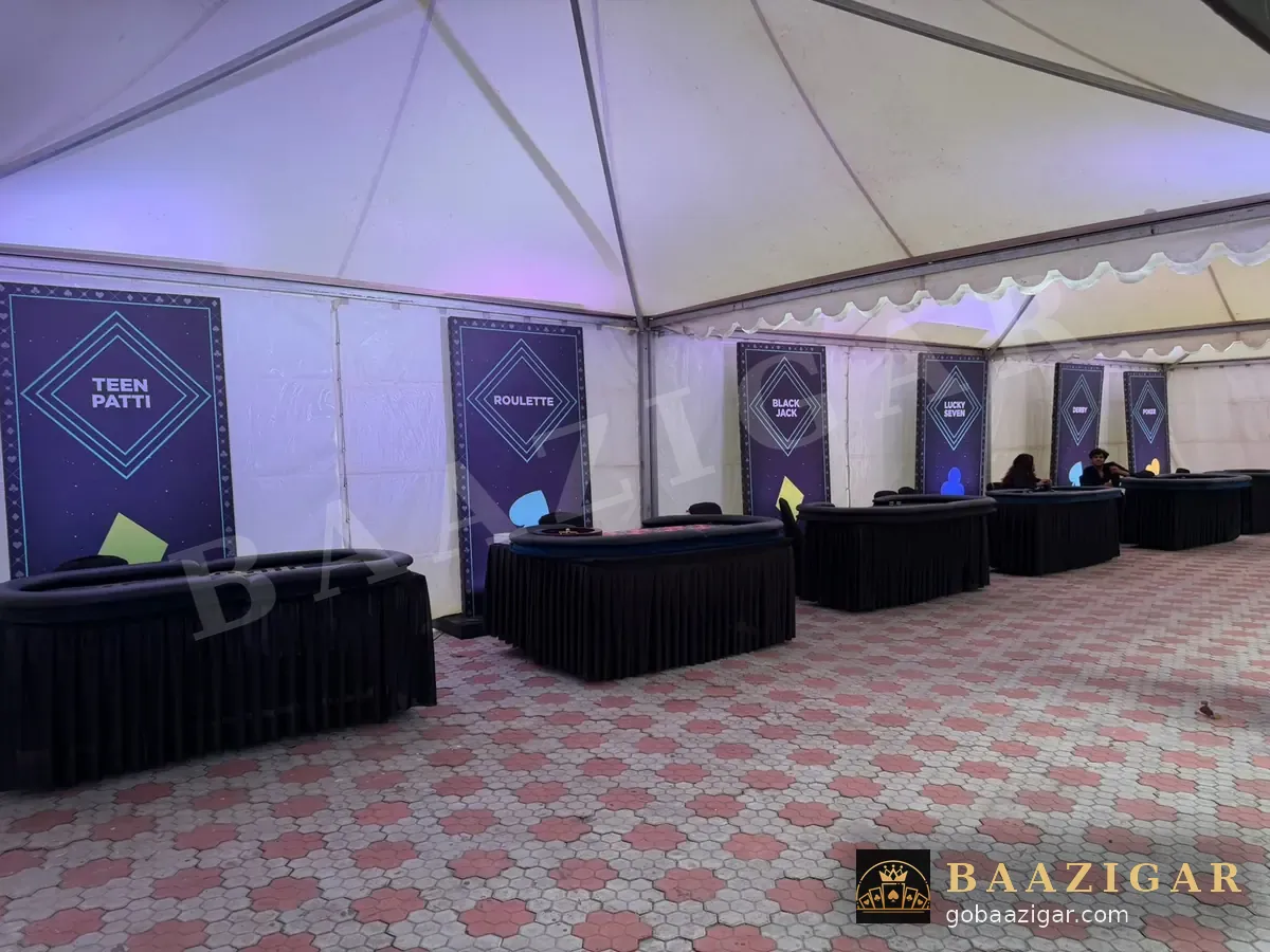 A row of casino tables with backdrops in an event tent