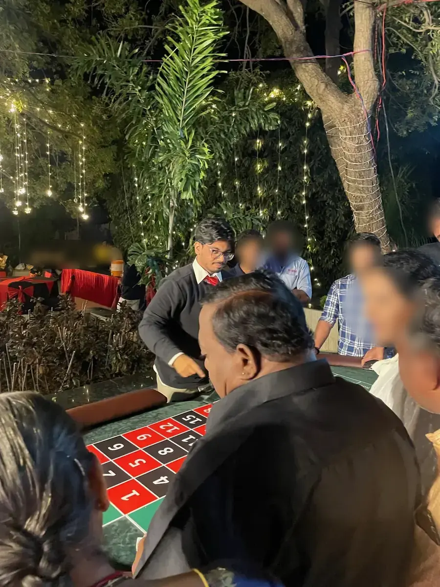 Dealer spinning roulette for a crowd of guests at night