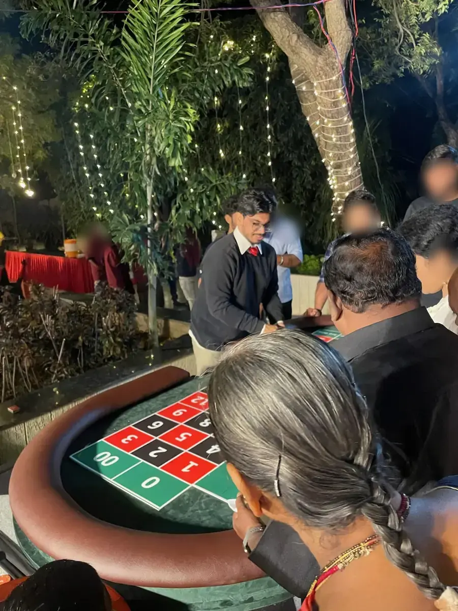 Guests crowd around a Baazigar roulette table at an evening garden party