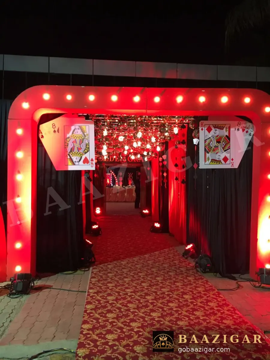 Casino-themed entrance arch with marquee lights and giant playing cards