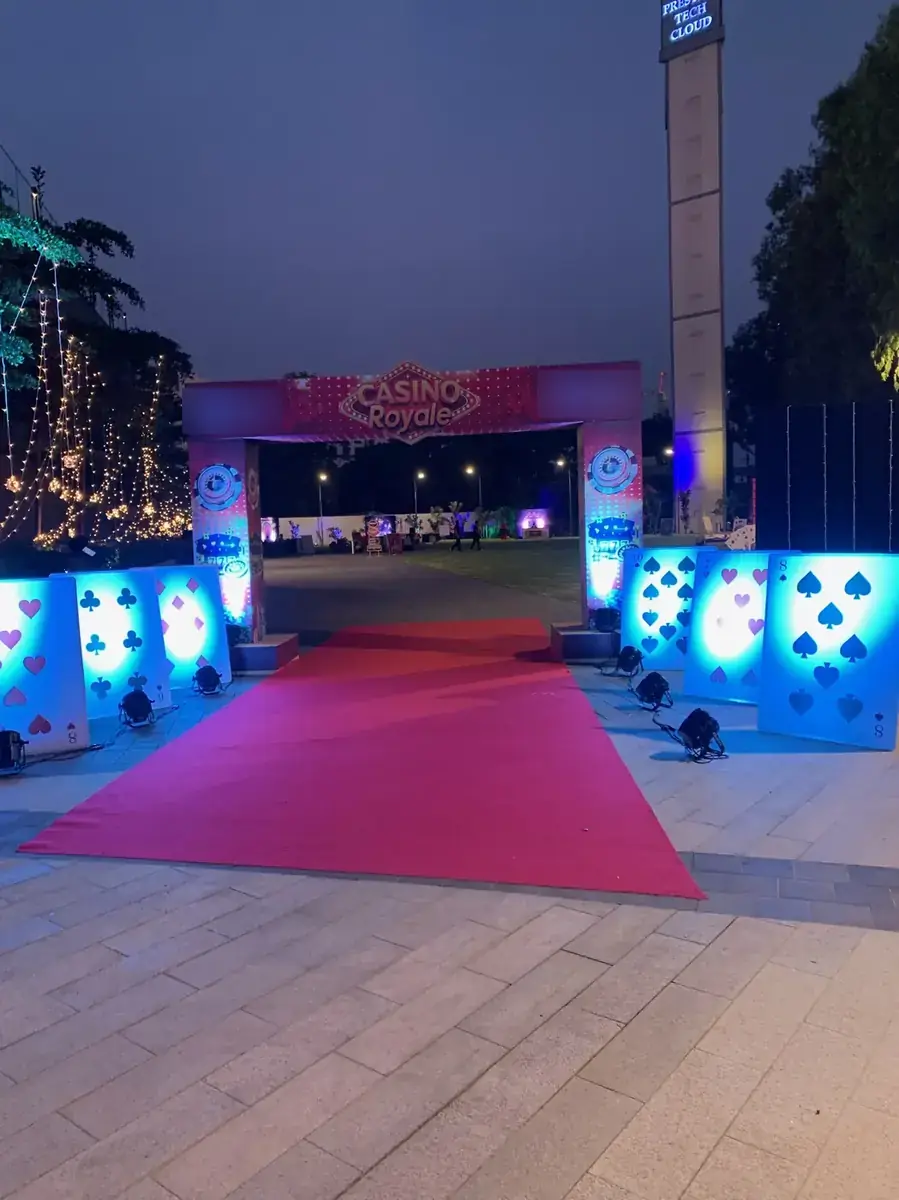 Red-carpet walkway lined with glowing card-suit panels
