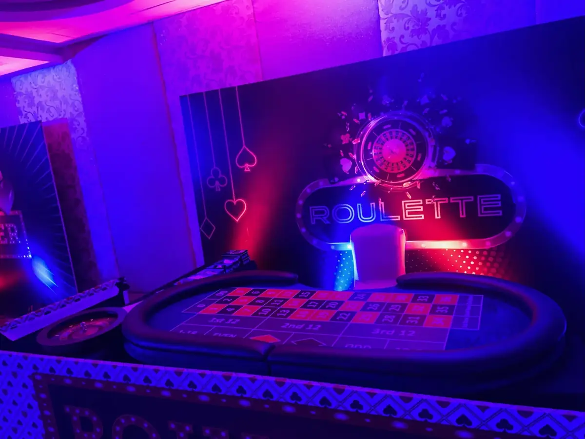 Roulette station glowing under party lights
