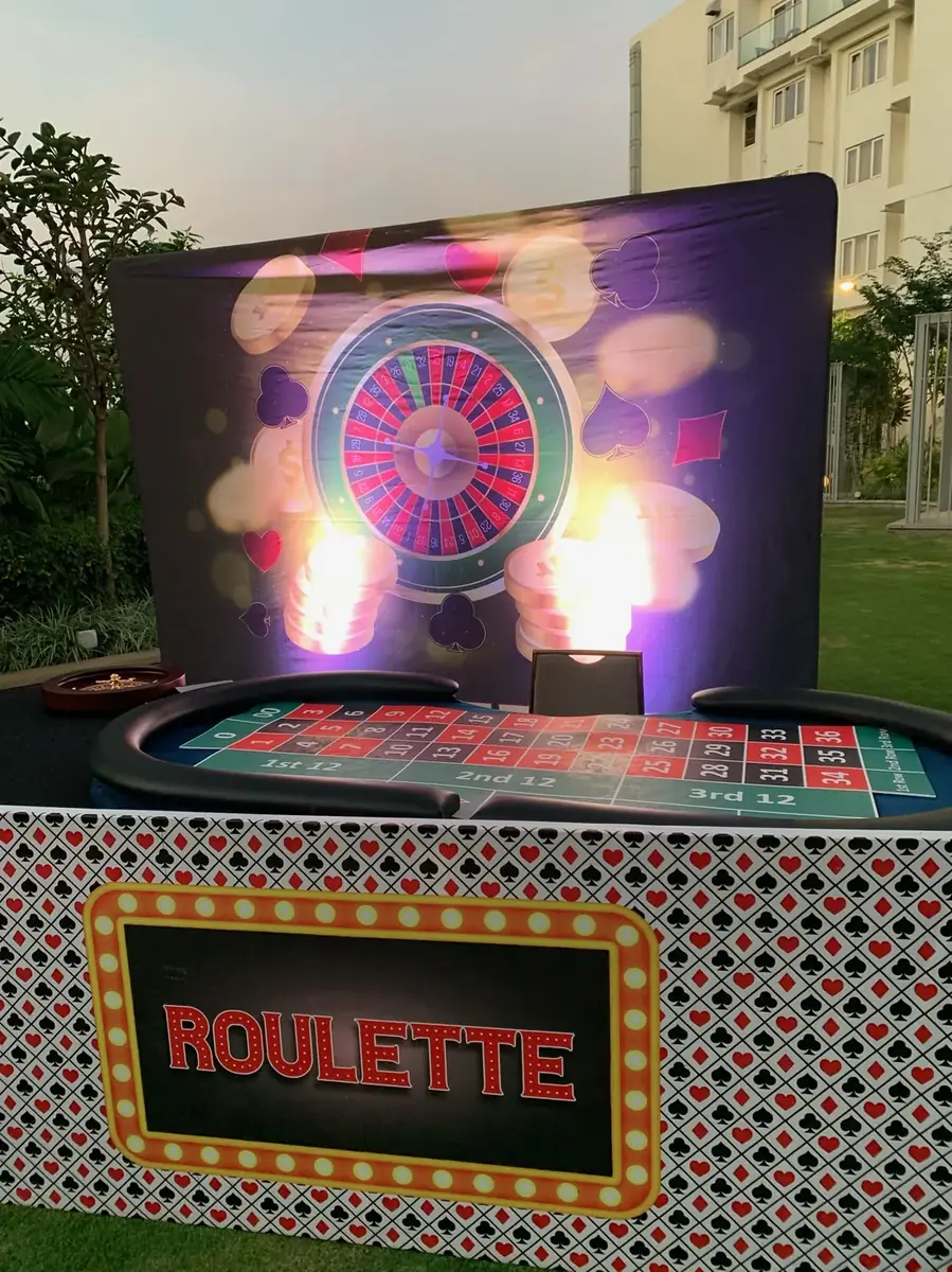 Roulette station lit up at dusk with a themed backdrop