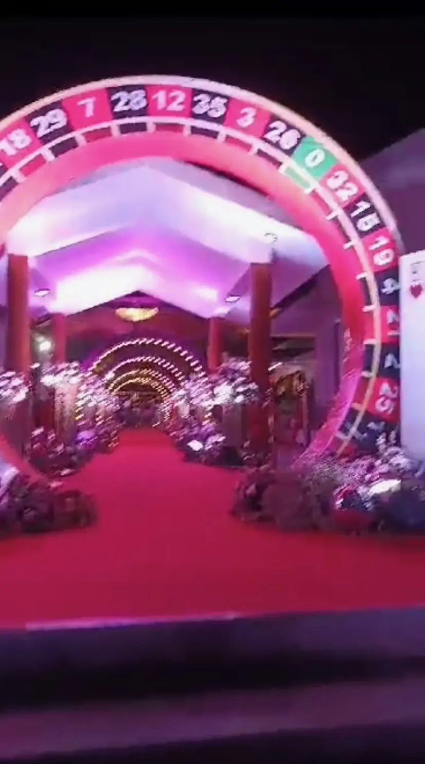 Roulette-wheel arch over a red-carpet wedding entrance